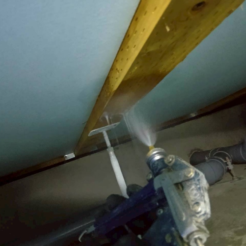 床下木材に防蟻剤を吹き付ける様子