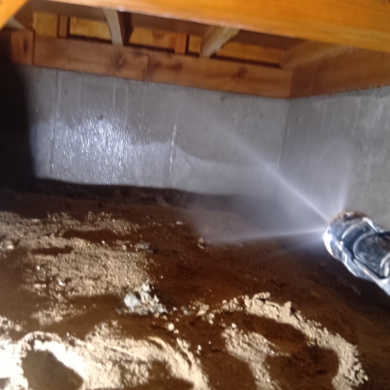 基礎にシロアリ駆除剤を吹き付けている様子