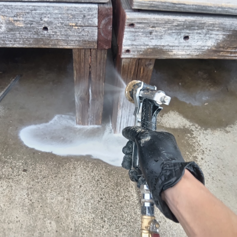 ウッドデッキにシロアリ駆除剤を吹き付ける様子