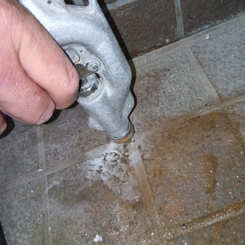 玄関の床にシロアリ駆除剤を注入する様子