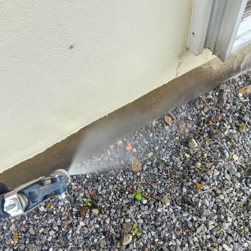 基礎まわりにシロアリ駆除剤を散布する様子