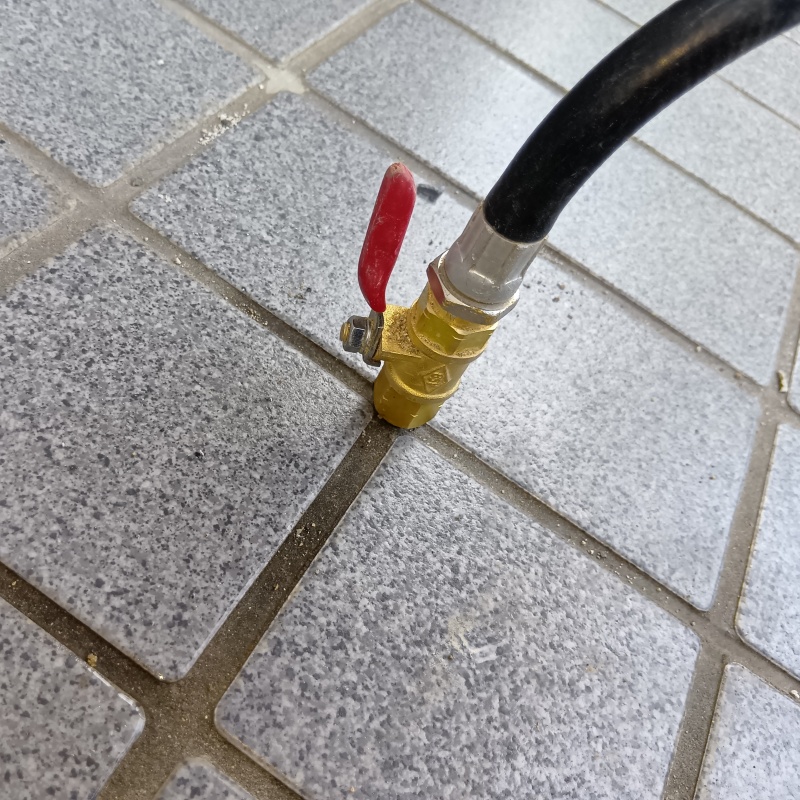 玄関の床にシロアリ駆除剤を注入する様子