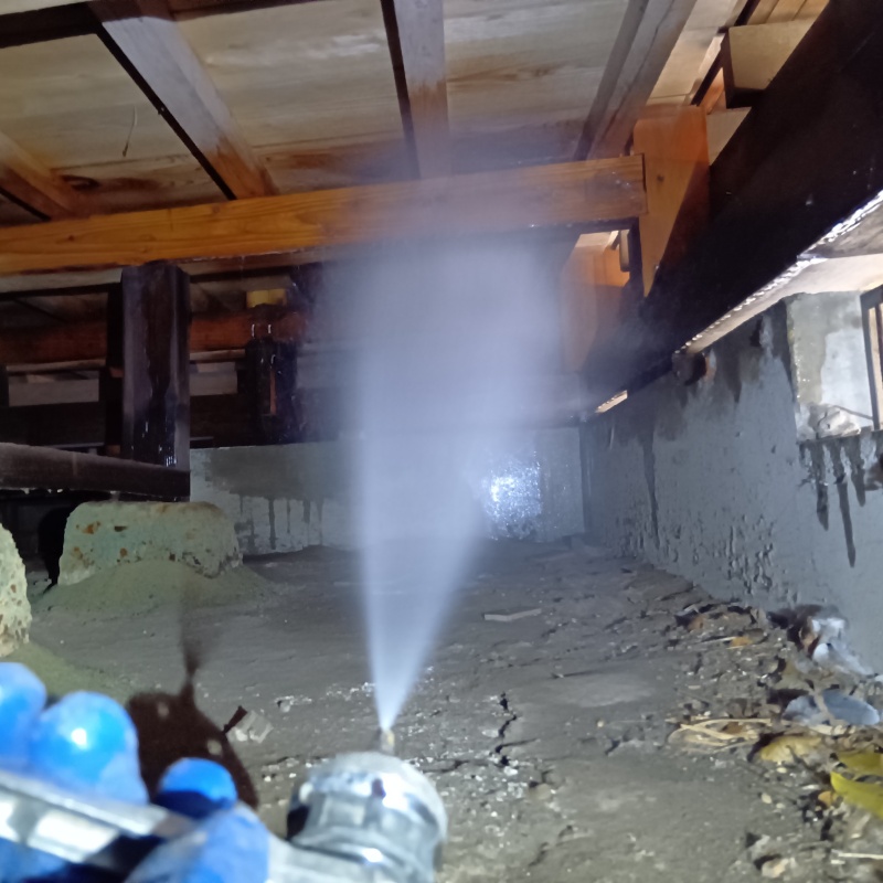 床下の木材にシロアリ駆除剤を散布する様子