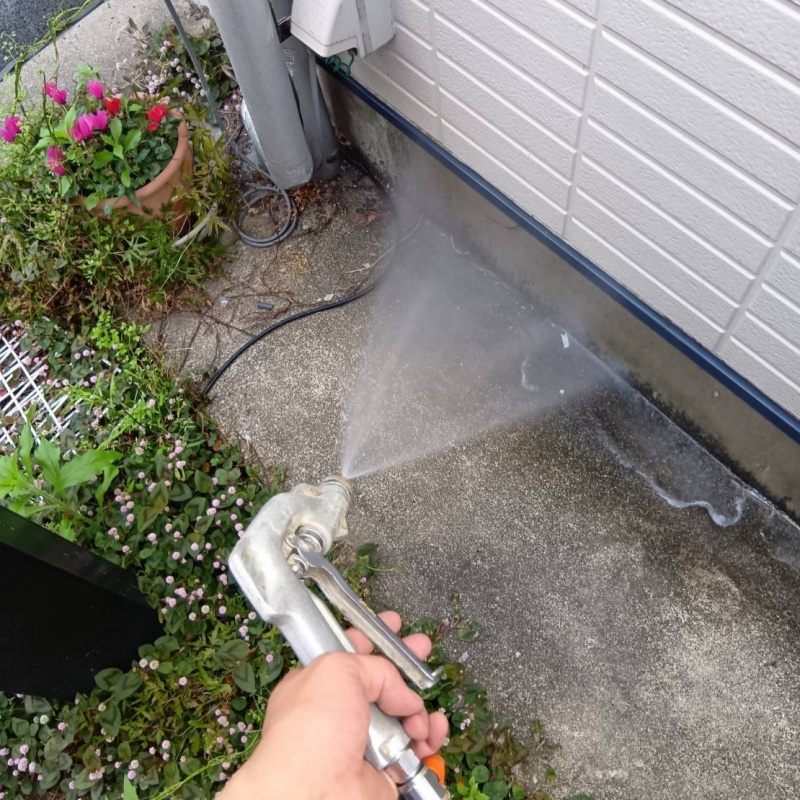 基礎まわりにシロアリ駆除剤を散布する様子