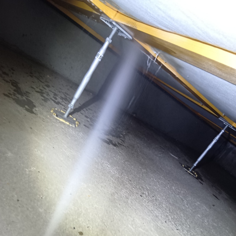 床下の木材にシロアリ駆除剤を散布する様子