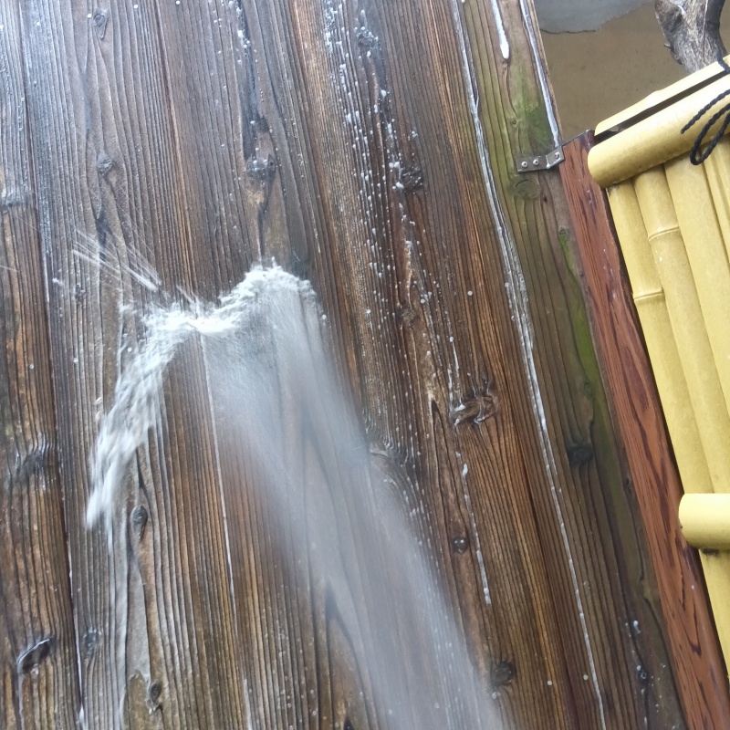 木塀にシロアリ駆除剤を吹き付ける様子