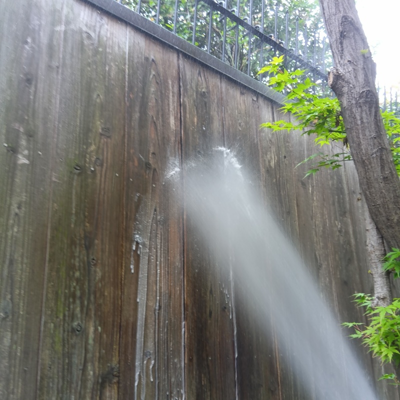 木塀にシロアリ駆除剤を吹き付ける様子