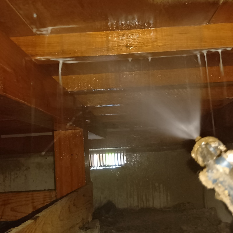床下の木材にシロアリ駆除剤を散布する様子