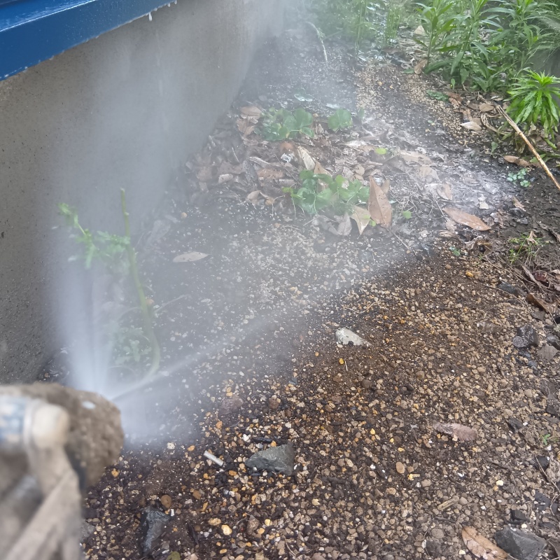 基礎まわりにシロアリ駆除剤を散布する様子