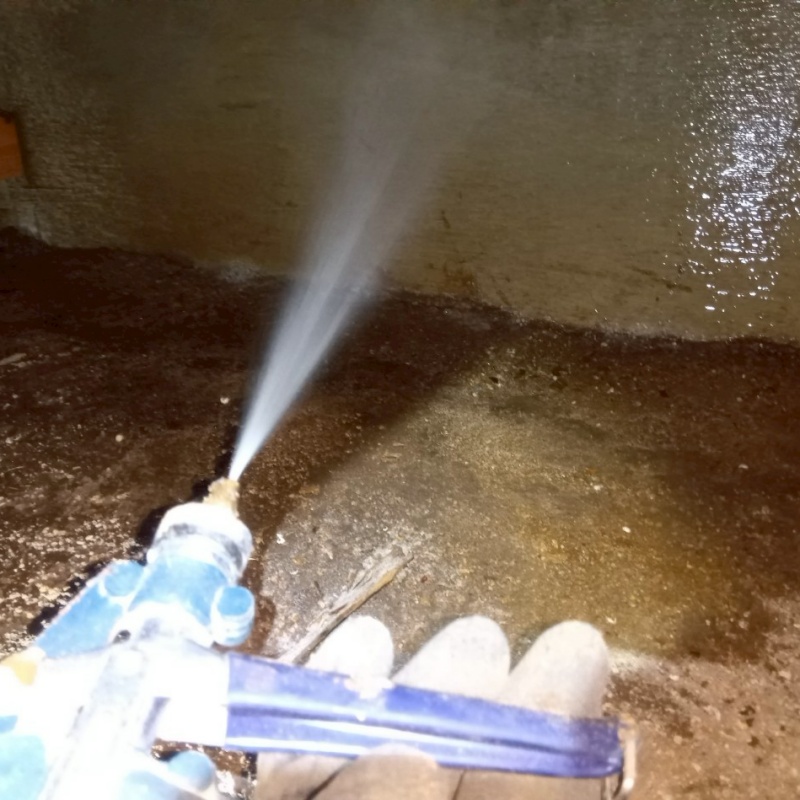 床下の基礎部分にシロアリ駆除剤を散布する様子