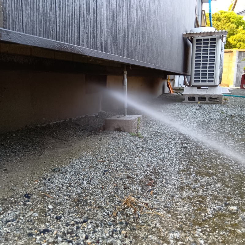 基礎まわりにシロアリ駆除剤を散布する様子