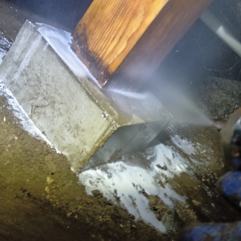 床下の基礎部分にシロアリ駆除剤を散布する様子