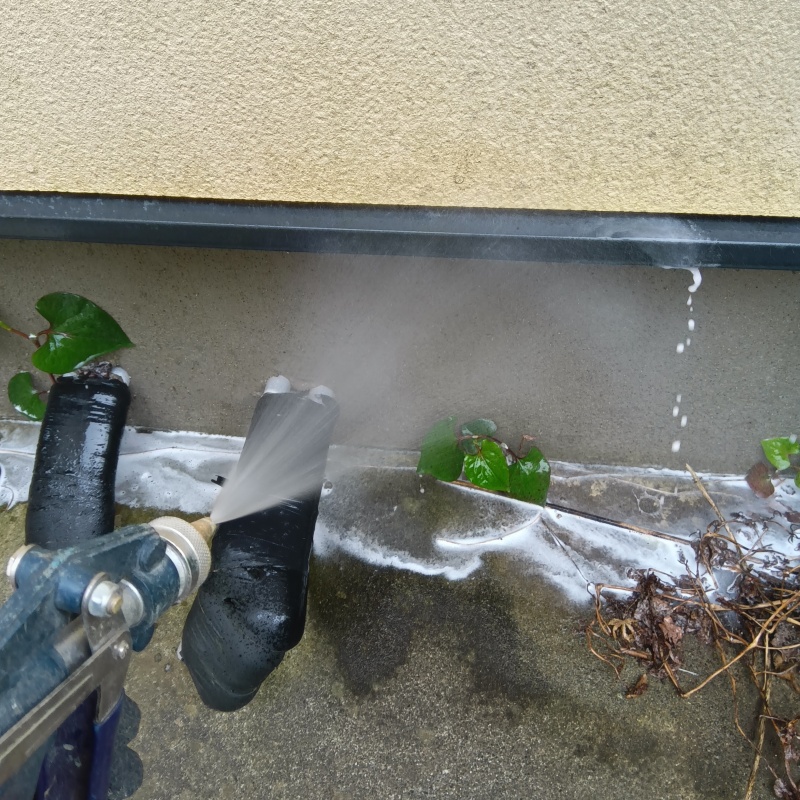 基礎まわりにシロアリ駆除剤を散布する様子