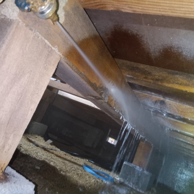 床下の木材にシロアリ駆除剤を散布する様子