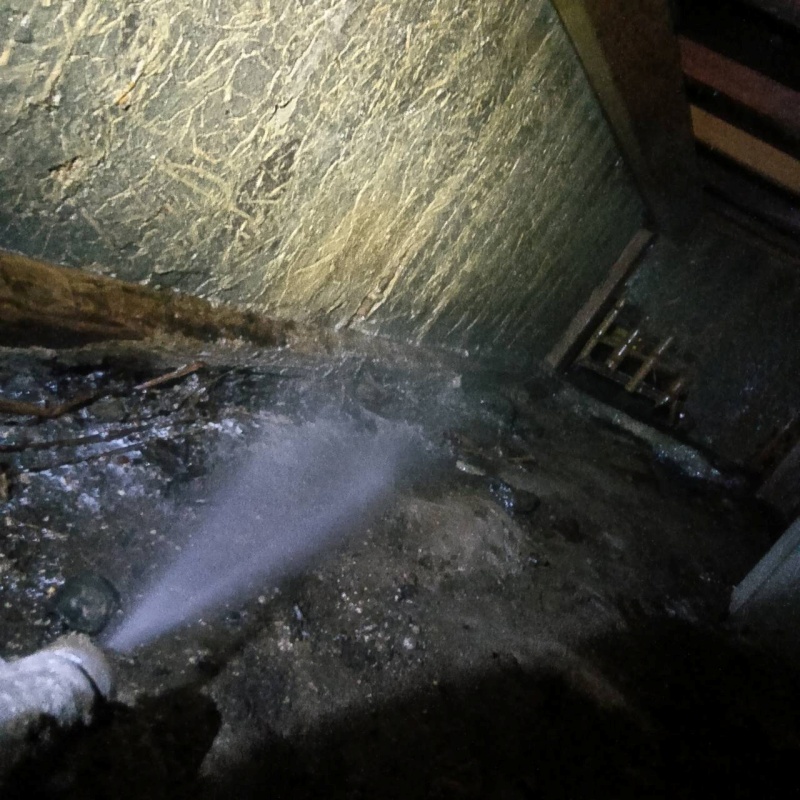 床下の土壌にシロアリ駆除剤を散布する様子