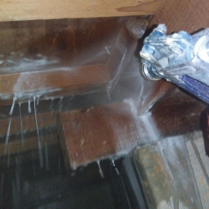 床下の木材にシロアリ駆除剤を散布する様子