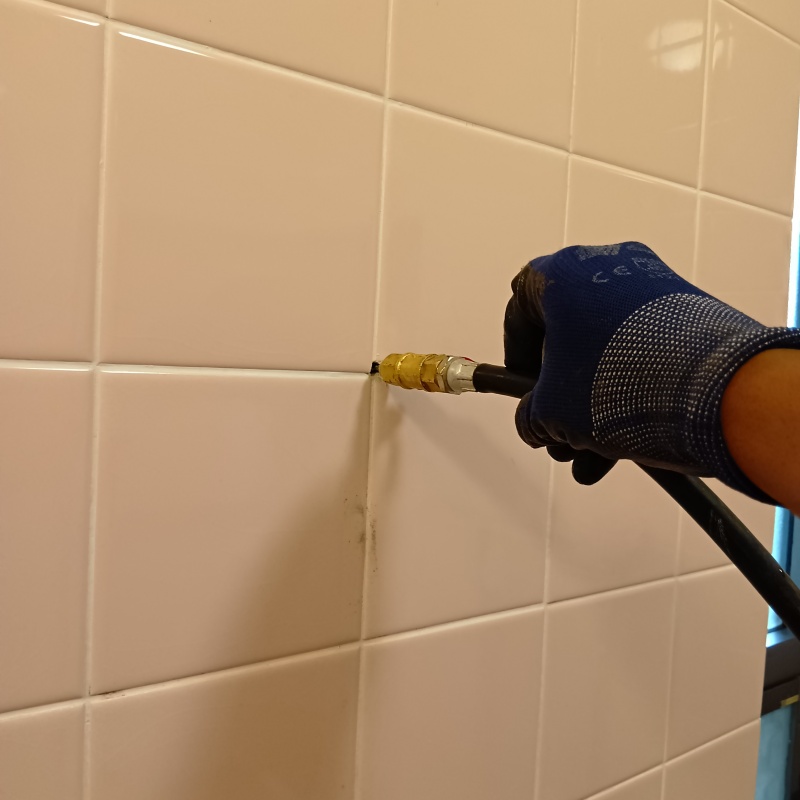 トイレの壁にシロアリ駆除剤を注入する様子
