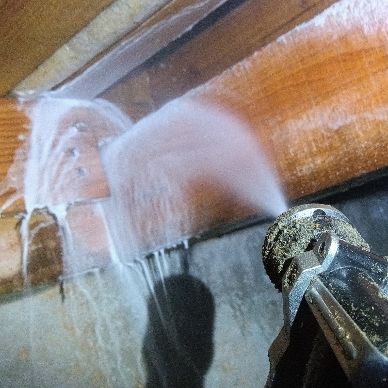 床下の木材にシロアリ駆除剤を散布する様子