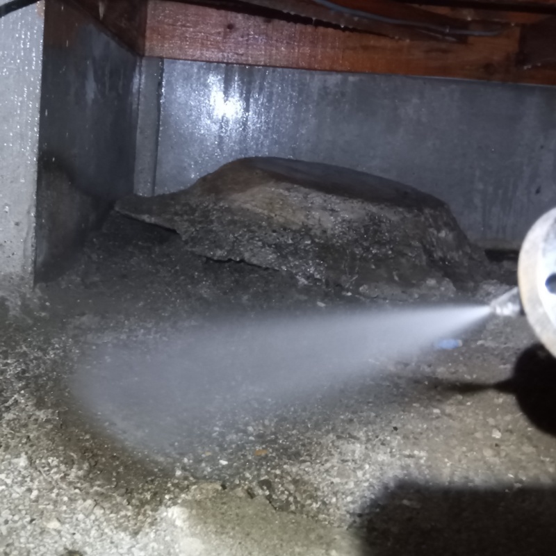 床下の土壌にシロアリ駆除剤を散布する様子