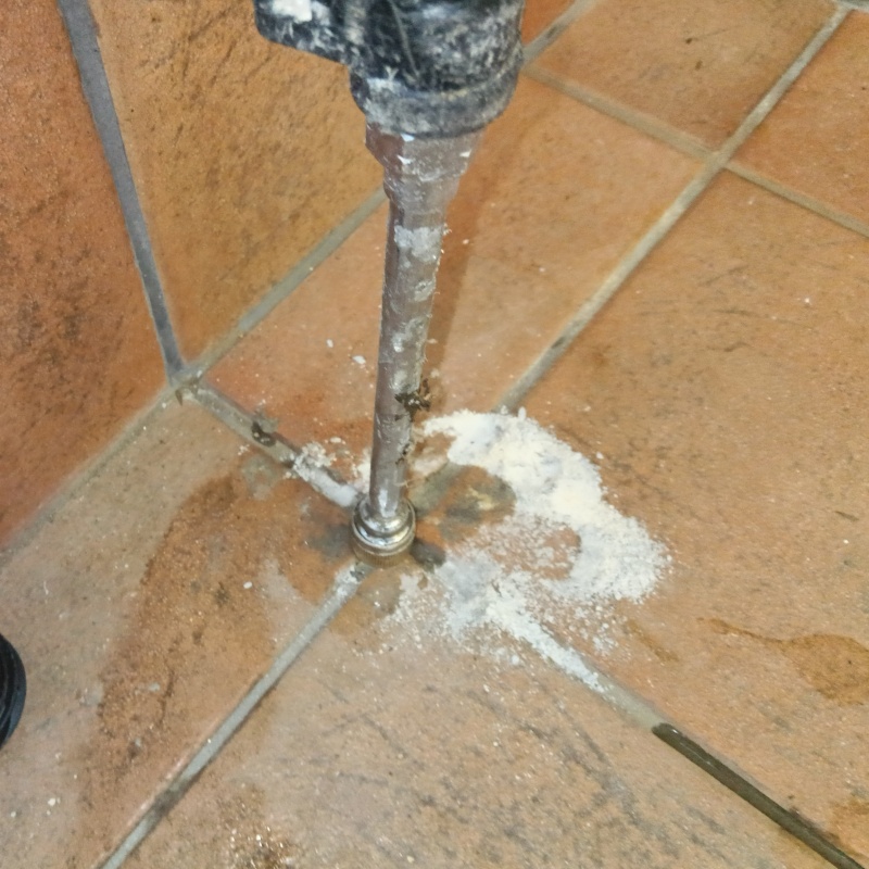 玄関の床にシロアリ駆除剤を注入する様子