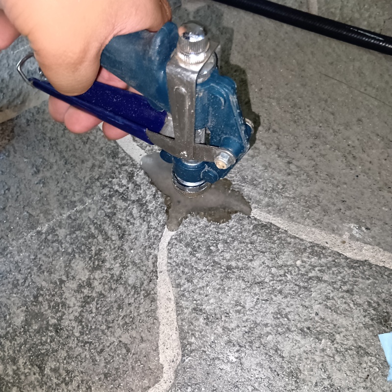 玄関の床にシロアリ駆除剤を注入する様子