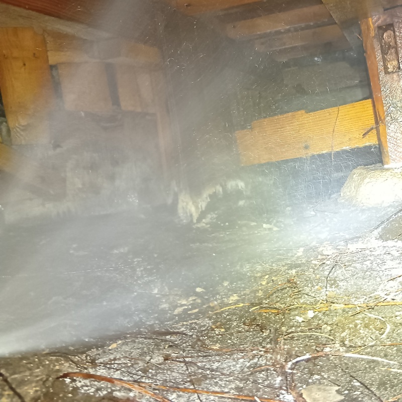 床下の土壌にシロアリ駆除剤を散布する様子