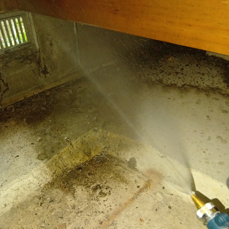 床下の基礎部分にシロアリ駆除剤を散布する様子