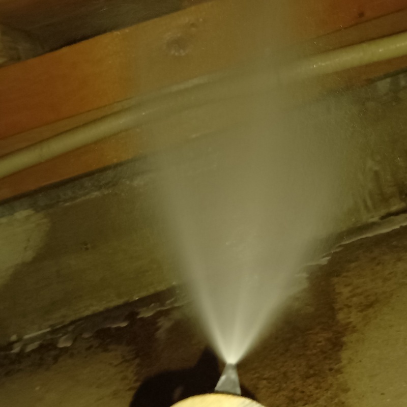 床下の木材にシロアリ駆除剤を散布する様子