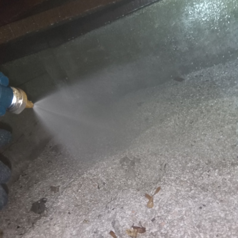 床下の土壌にシロアリ駆除剤を注入する様子