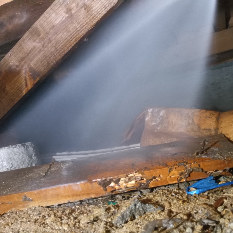 床下の土壌にシロアリ駆除剤を散布する様子