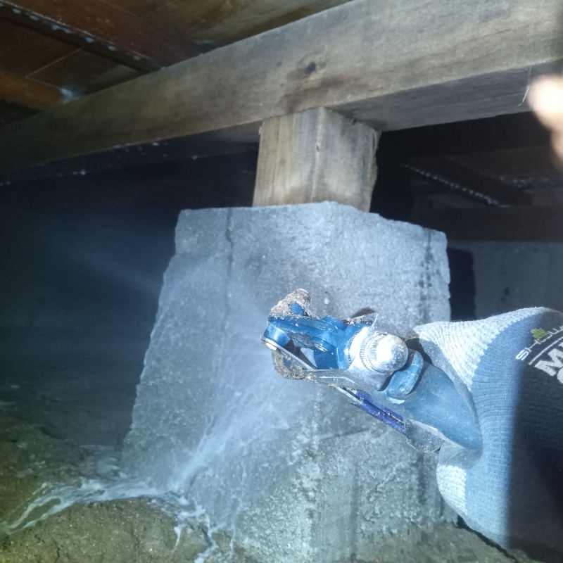 床下の基礎部分にシロアリ駆除剤を散布する様子