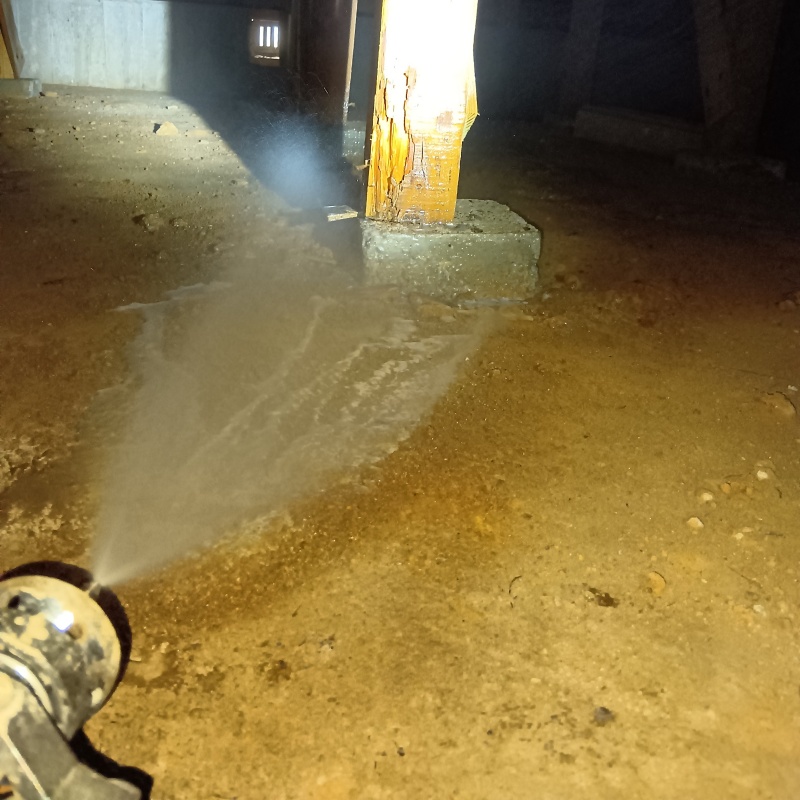 床下の土壌にシロアリ駆除剤を散布する様子