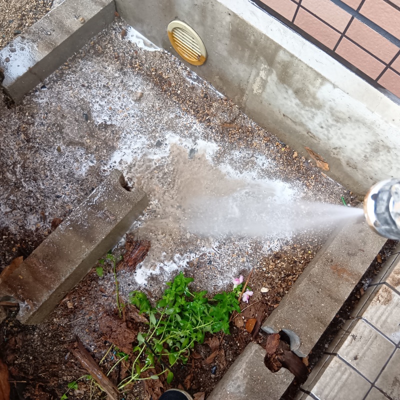 基礎まわりににシロアリ駆除剤を散布する様子