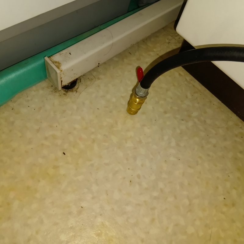 洗面所の床にシロアリ駆除剤を注入する様子