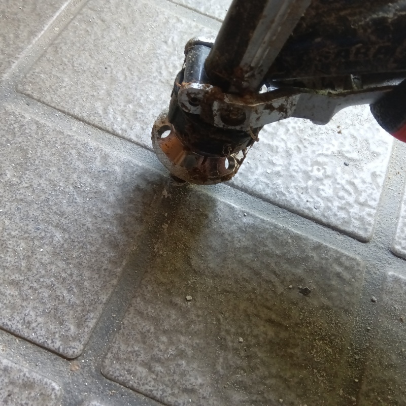 玄関の床にシロアリ駆除剤を注入する様子