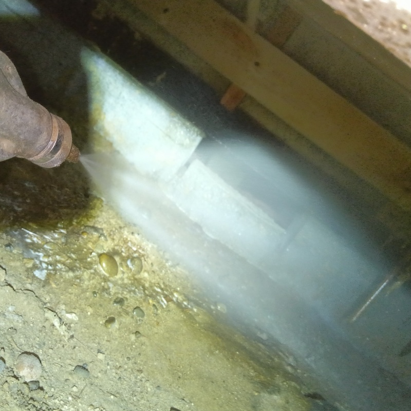 床下の土壌にシロアリ駆除剤を散布する様子