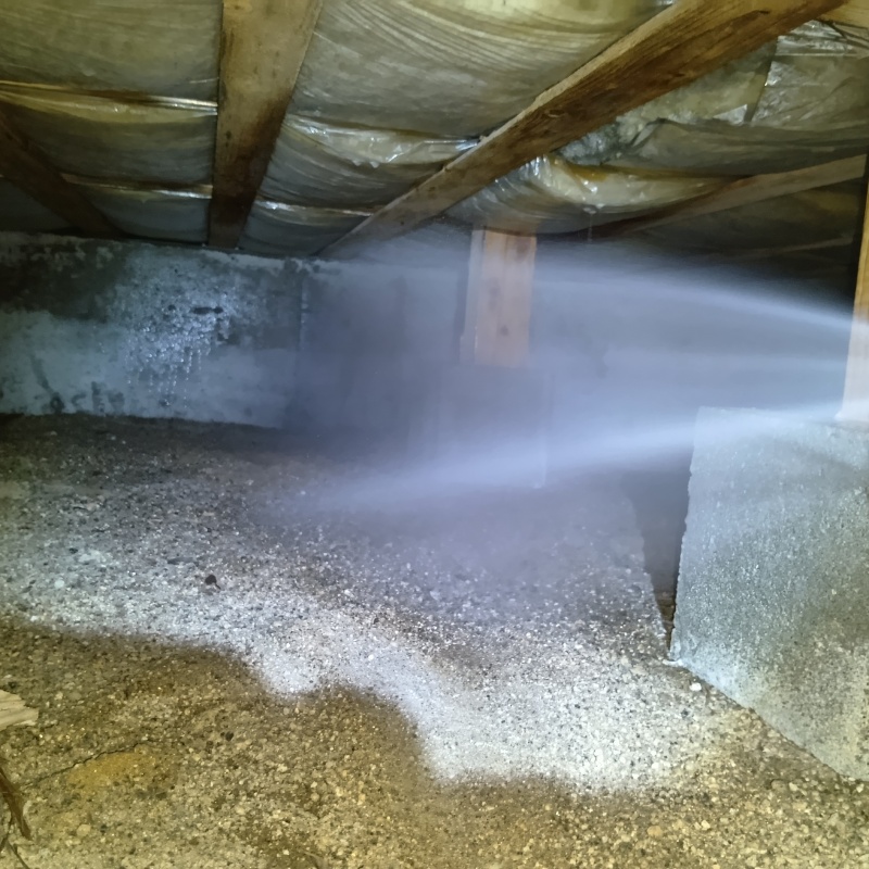床下の土壌にシロアリ駆除剤を散布する様子
