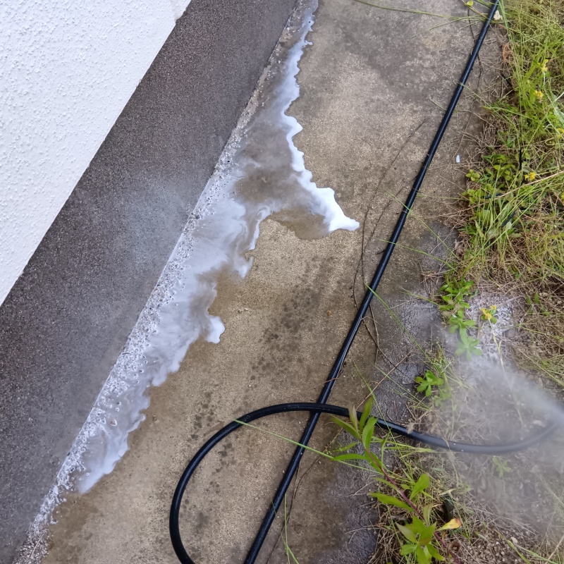 基礎まわりにシロアリ駆除剤を散布する様子