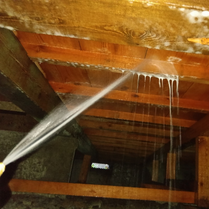 床下の木材にシロアリ駆除剤を散布する様子