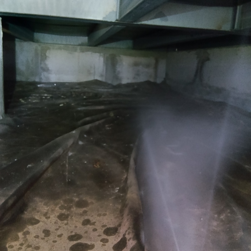 床下の土壌にシロアリ駆除剤を散布する様子