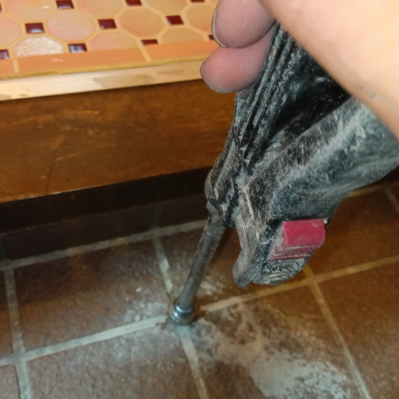 玄関の床にシロアリ駆除剤を注入する様子