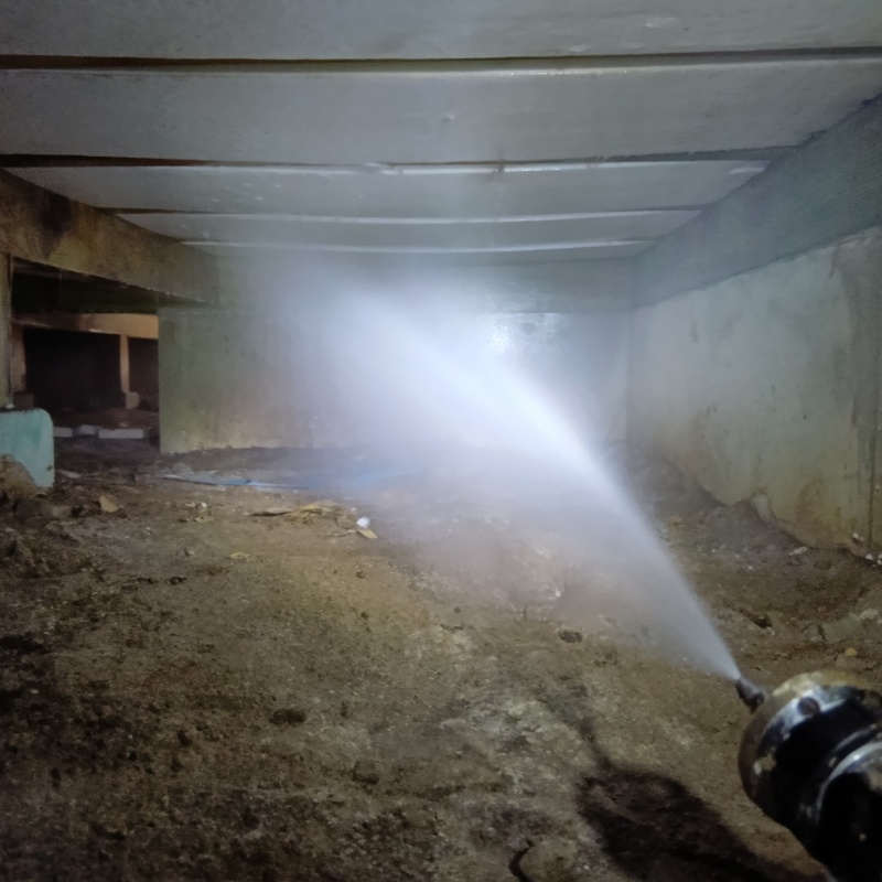 床下の土壌にシロアリ駆除剤を散布する様子