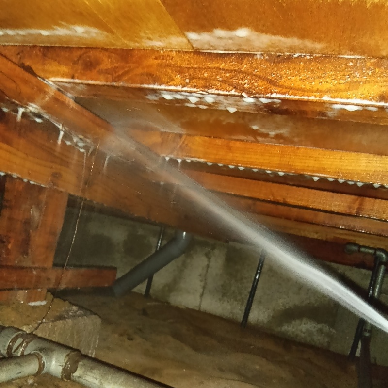 床下の木材にシロアリ駆除剤を散布する様子