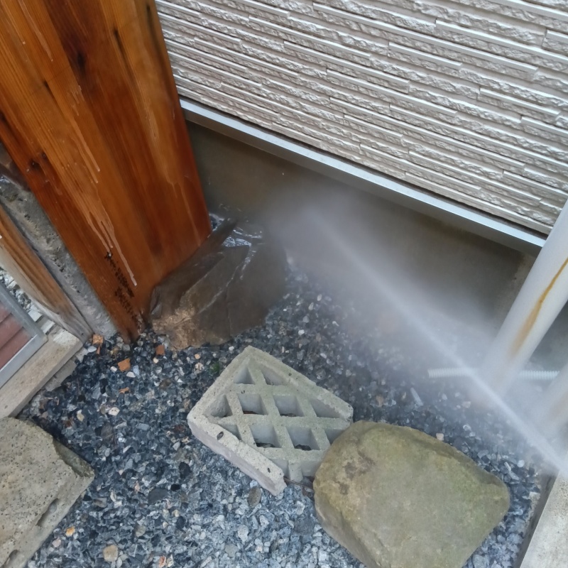 基礎まわりにシロアリ駆除剤を散布する様子