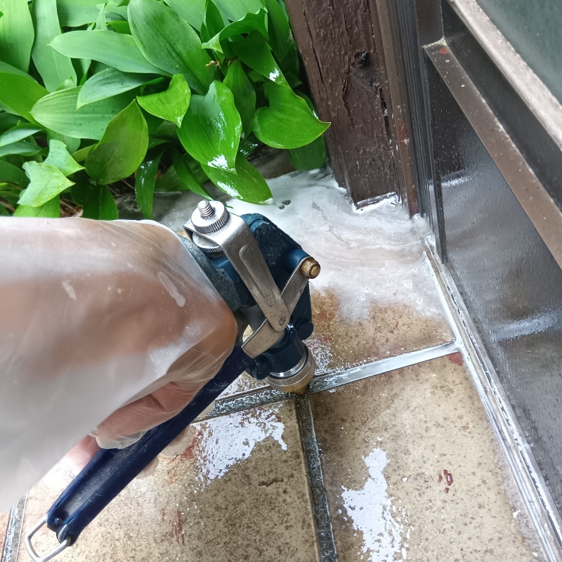 玄関の床にシロアリ駆除剤を注入する様子