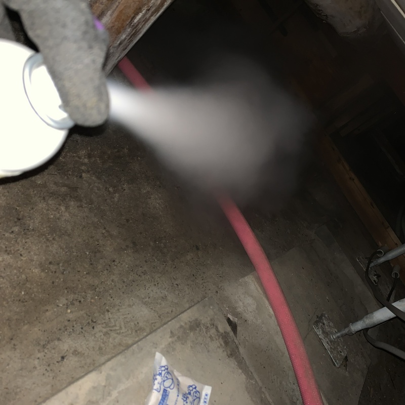 床下に忌避剤を散布する様子