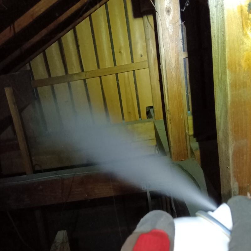 屋根裏に忌避剤を散布する様子