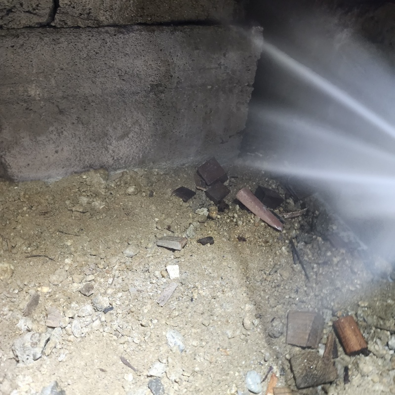 床下の土壌にシロアリ駆除剤を散布する様子