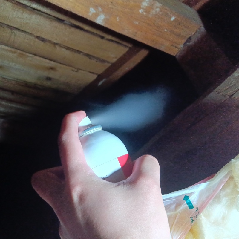 屋根裏に忌避剤を散布する様子