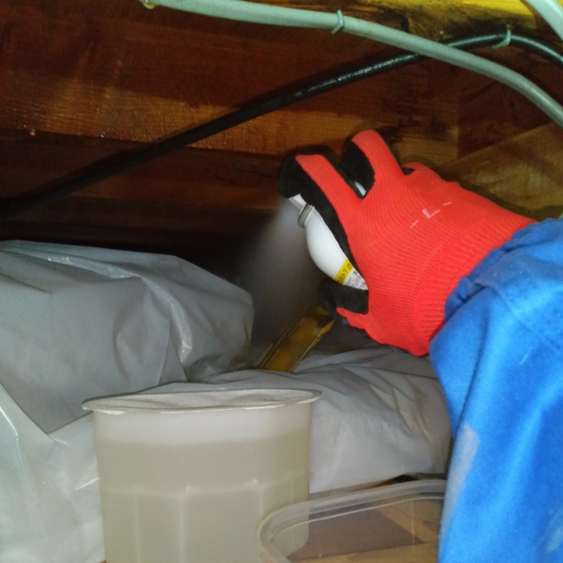 屋根裏に忌避剤を散布する様子